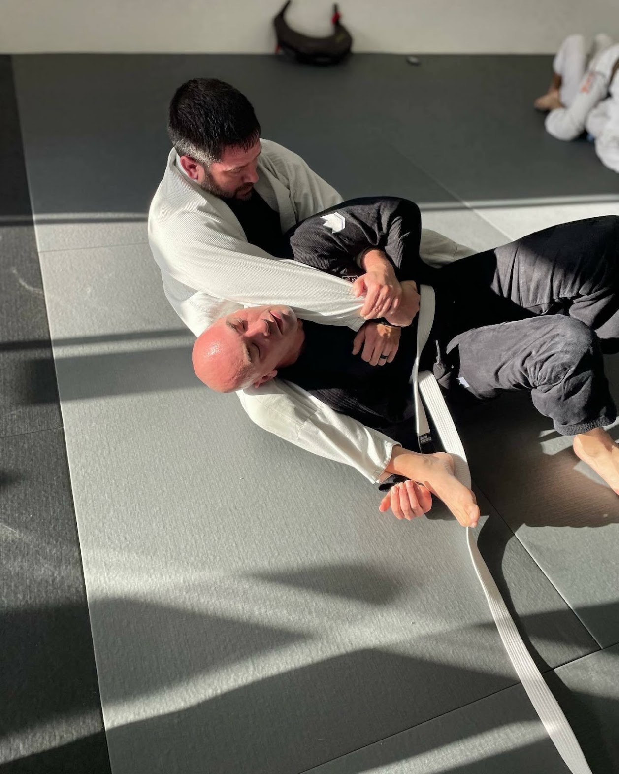 Adult student practicing back control choke technique on the mat at Five Peaks Jiu Jitsu