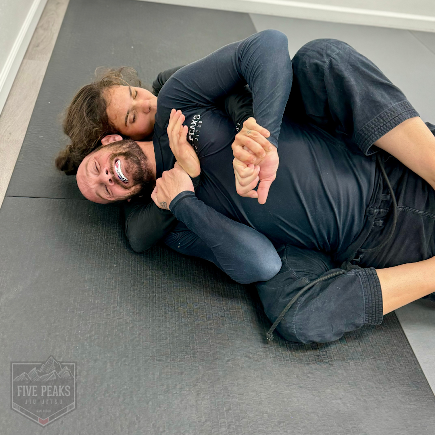 Two students grappling on the mat during training at Five Peaks Jiu Jitsu