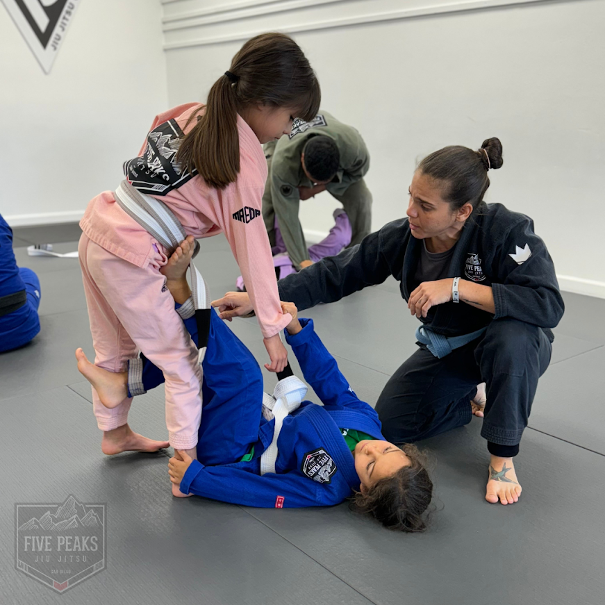 Coach encouraging a young student during jiu jitsu technique training at Five Peaks Jiu Jitsu