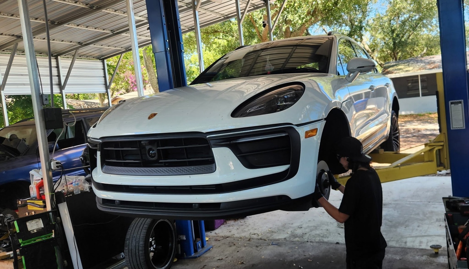 Technician servicing a wheel and brake area on a raised vehicle at Danny Auto Repair in Hudson, Florida.