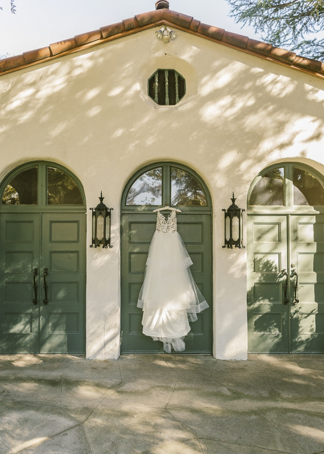 Perspective-corrected architectural photography of Spanish colonial villa with green arched doors and stone courtyard by Relative Vision Studio in Pomona, CA