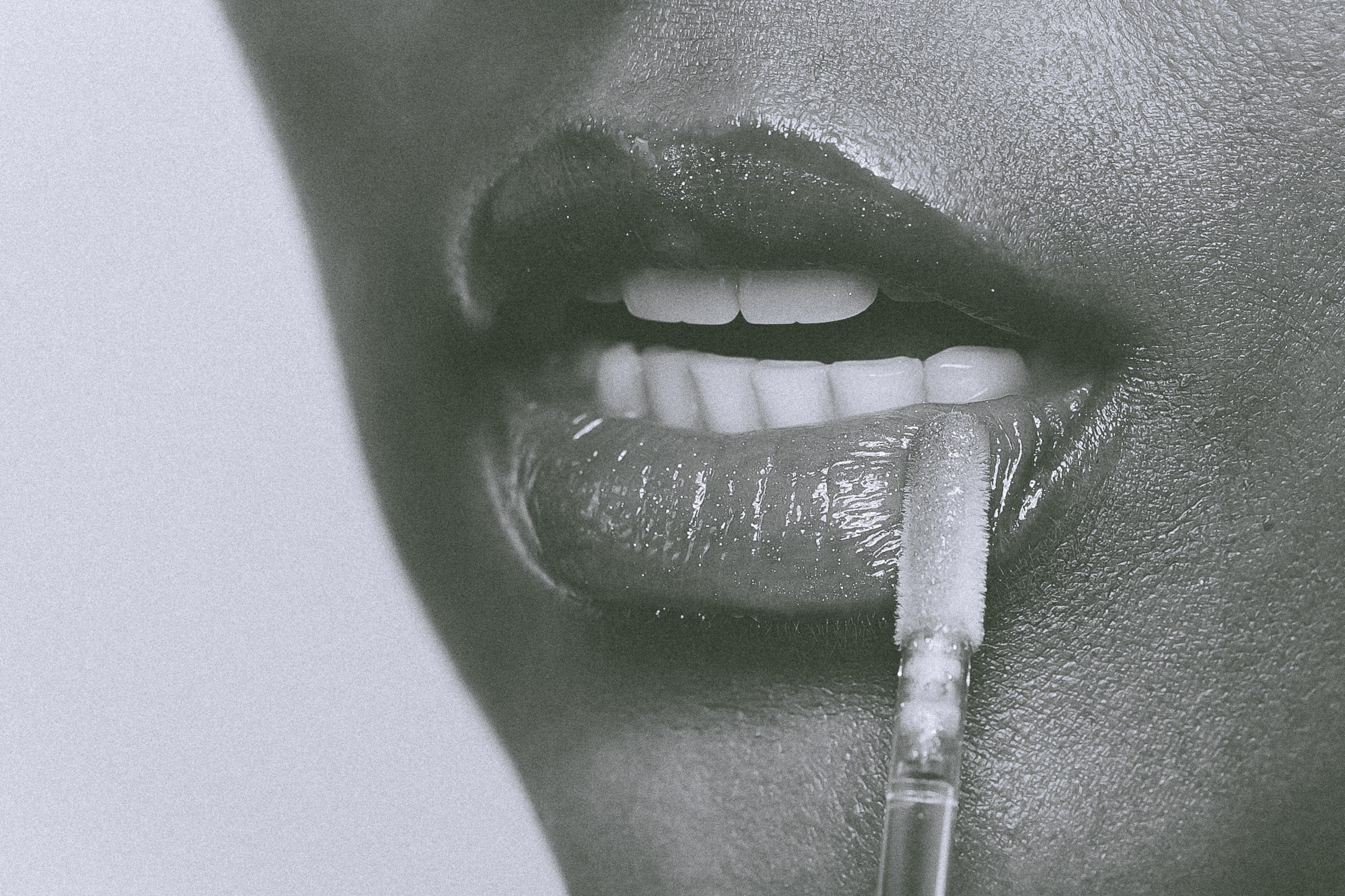 High-detail monochrome macro product photography of lip gloss wand application and shimmer texture by Relative Vision Studio serving Los Angeles and Inland Empire