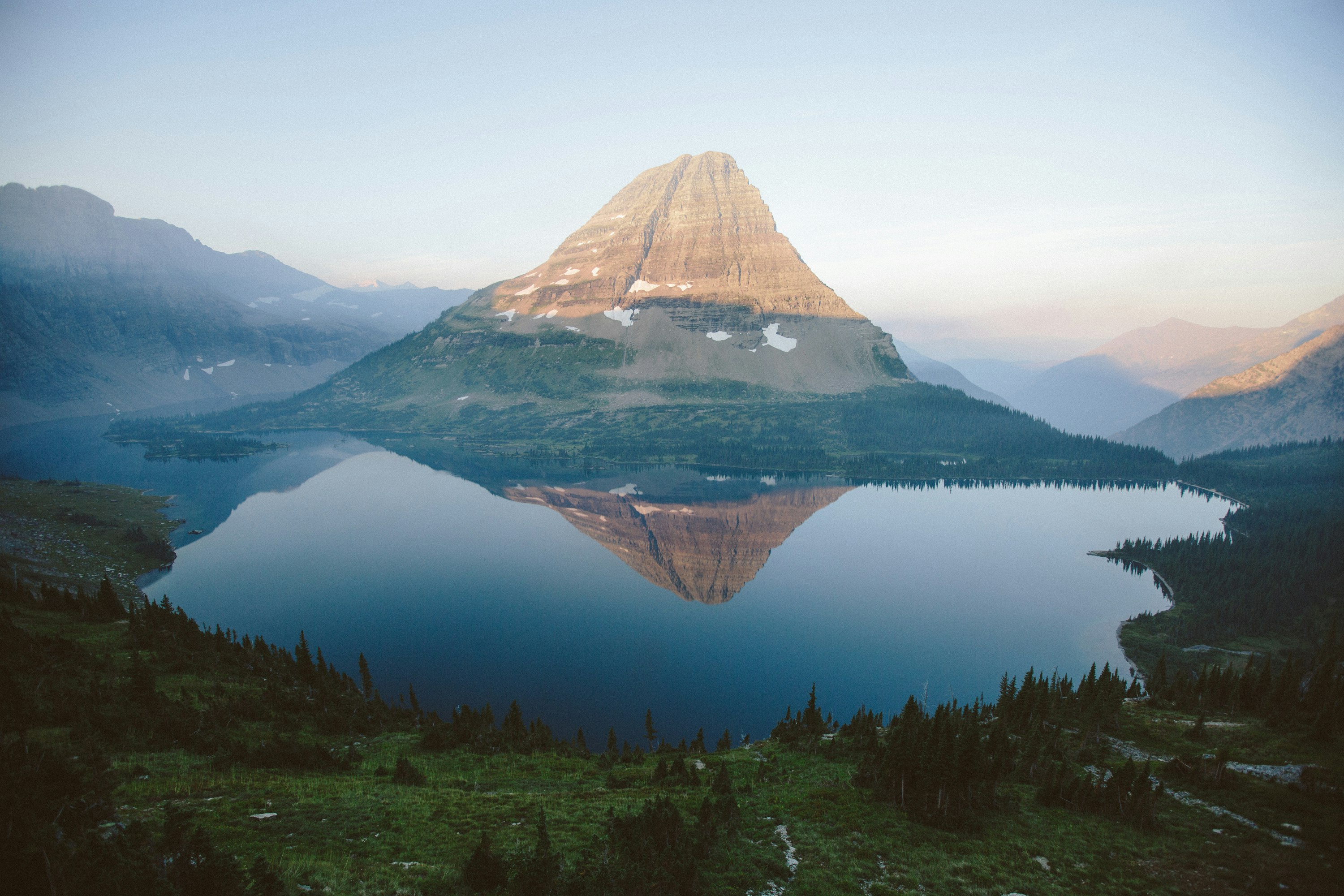 Aerial view of a still lake near Glacier National Park at sunrise — vibrant American wilderness