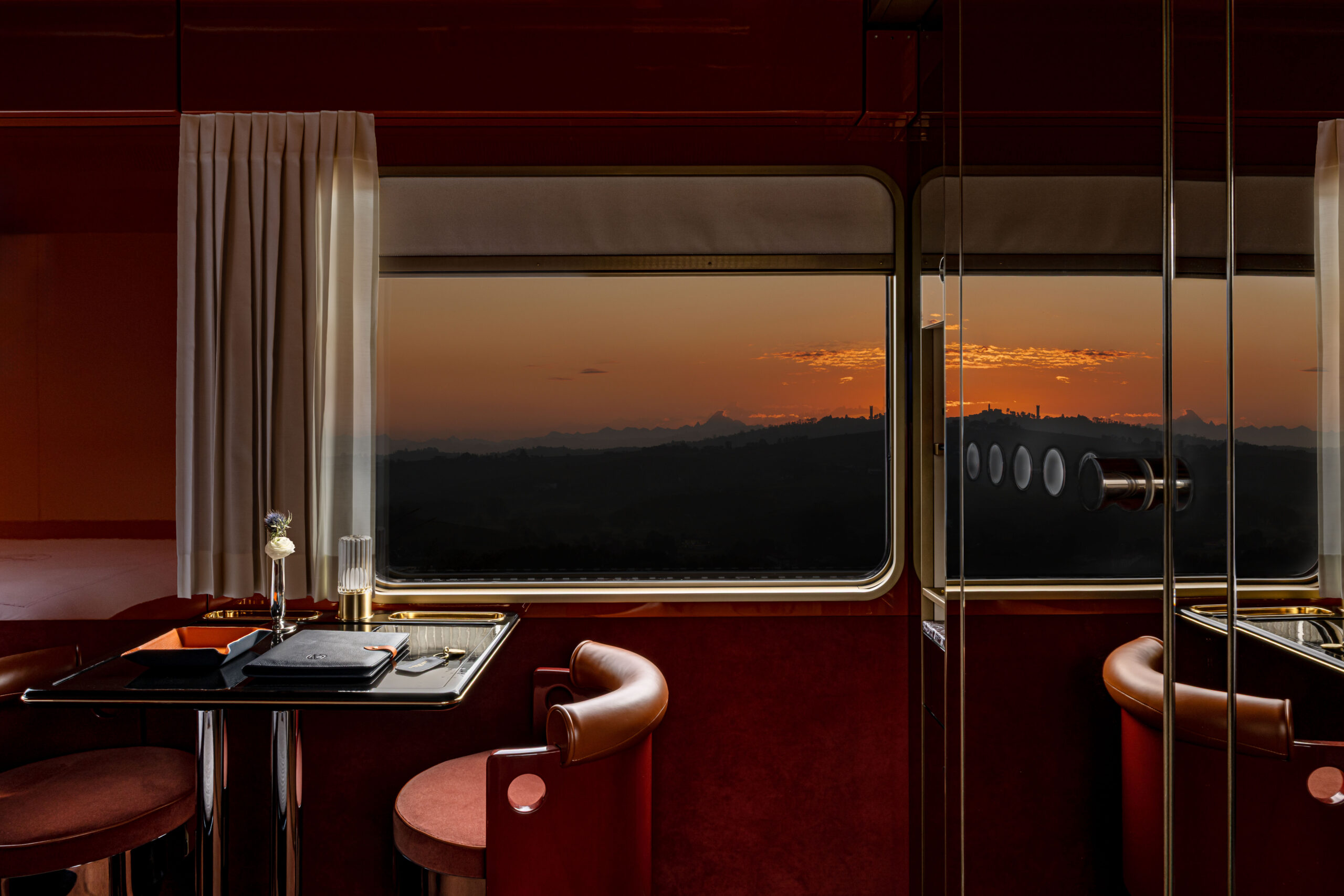 Luxury vintage train interior with brass and emerald velvet seating at dawn