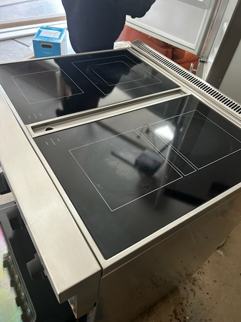 After cleaning: Sparkling restored electric range with high-gloss cooktop and pristine stainless steel finish