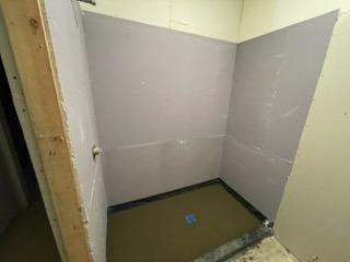 Cement board wall backing and shower pan preparation under construction