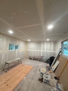Room transformation featuring taped and mudded drywall with LED recessed ceiling lighting