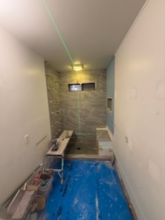 Precision green laser level line projection for full-height shower wall tile installation