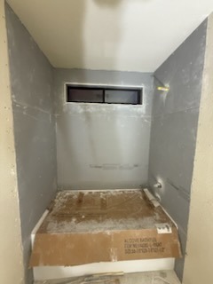 Custom alcove bathtub installation with high transom window framing and cement board backing