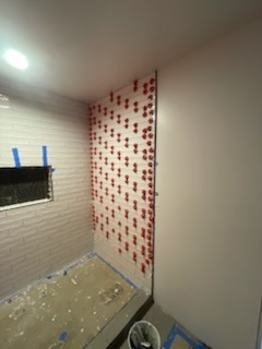 Precision tile setting on shower wall using tile leveling clips with recessed shower niche