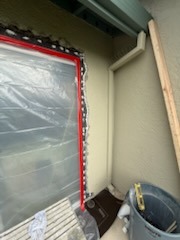 Exterior window trim wrap preparation with protective plastic sheeting and stucco wall