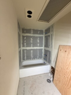 Bathtub installation with moisture-resistant drywall, taping, and ceiling ventilation
