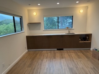 Custom built-in kitchenette cabinetry with wood countertop and luxury vinyl plank flooring