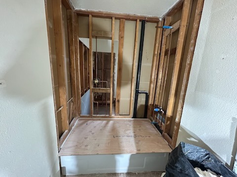 Structural timber stud framing and copper plumbing rough-in for new shower area