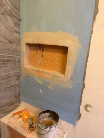 Waterproof recessed shower niche box installation with waterproof banding and surrounding tile