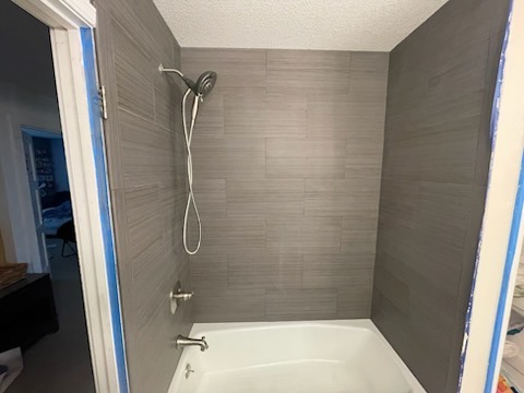 Bathtub surround with linear tile pattern installation and new fixtures