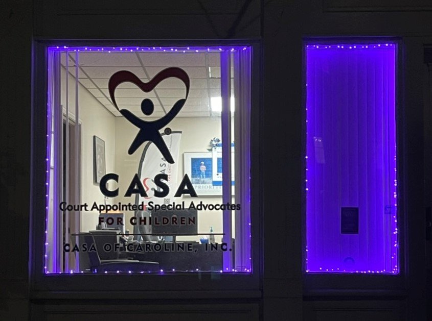 CASA of Caroline office window illuminated with purple lights.
