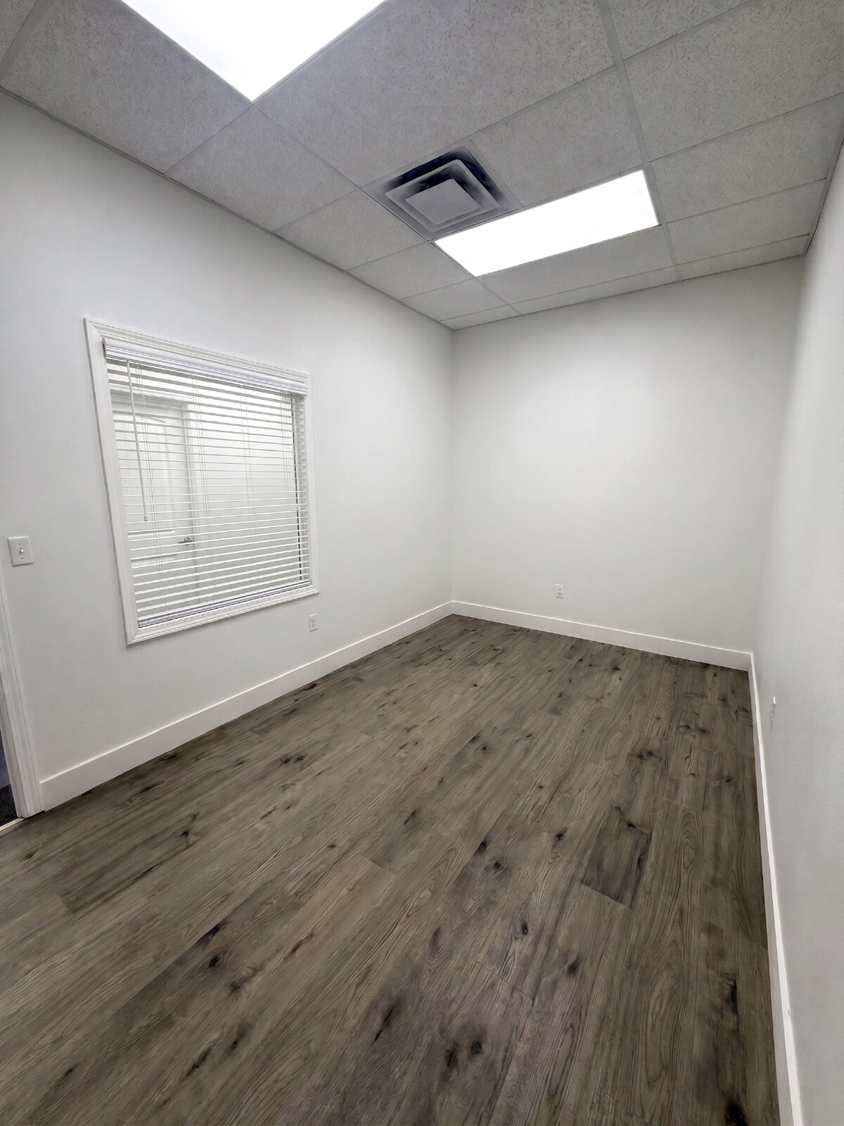 Remodeled office suite with window and vinyl plank flooring, available for rent in Rigby, Idaho