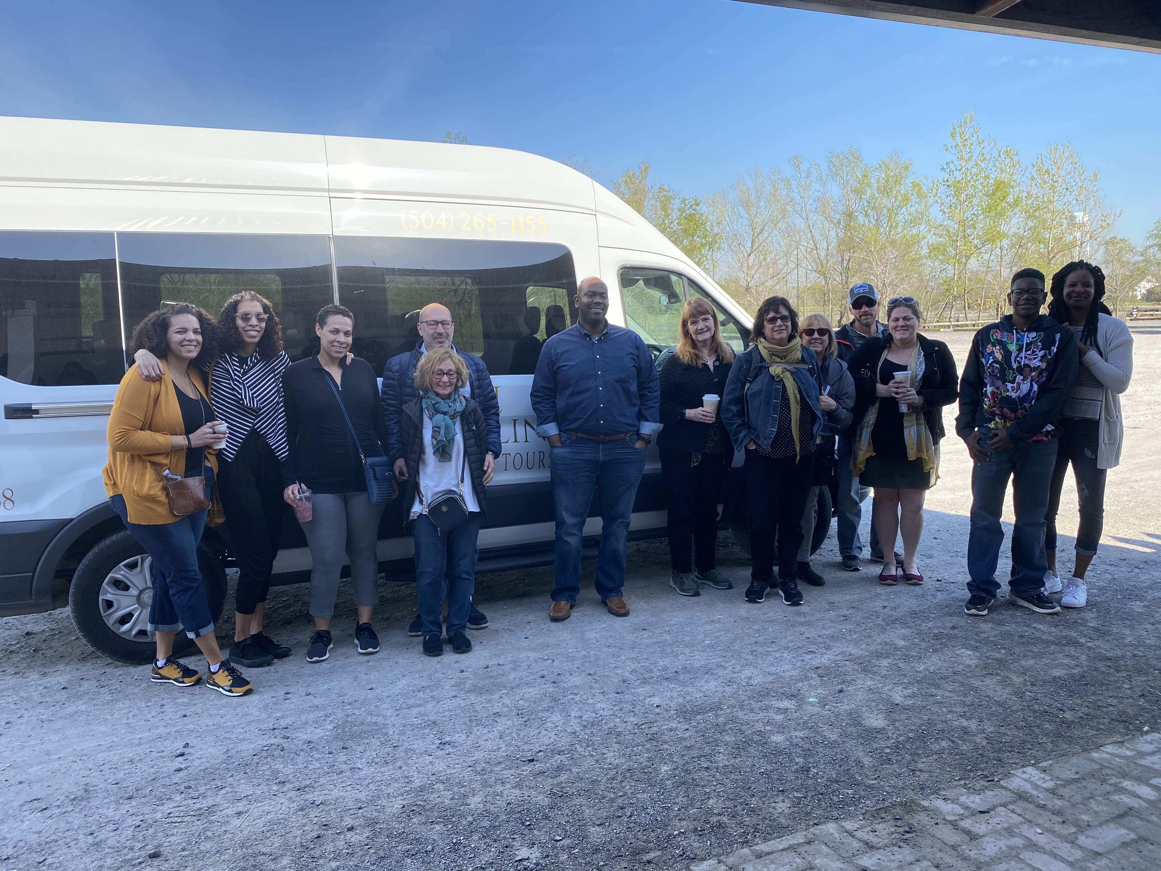 Guest group posing beside the N'awlins Luxury Tours minibus before departure