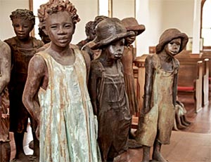 Close-up of sculpted clay children statues in plantation church sanctuary