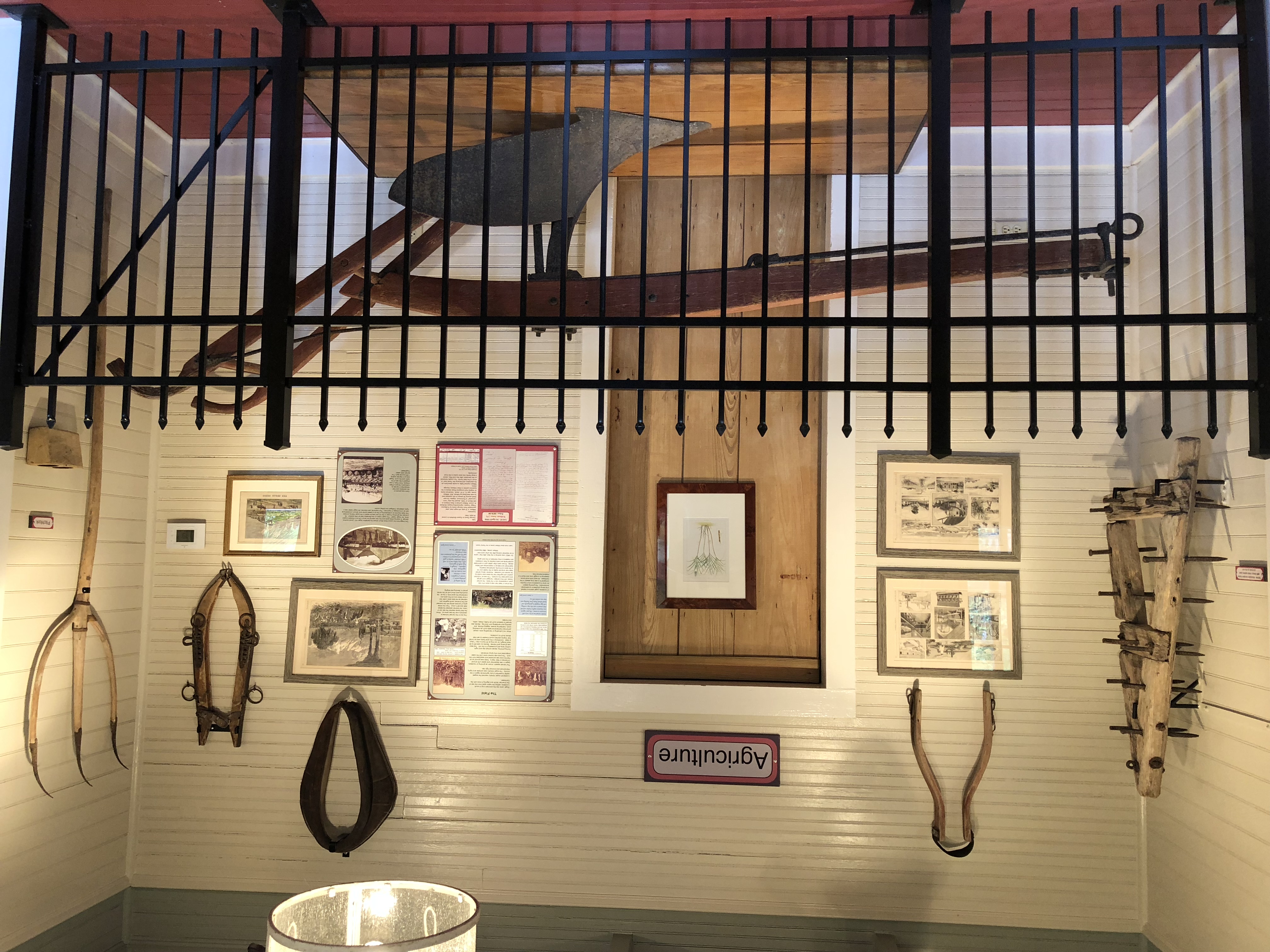Agriculture history museum display with wooden plow, horse yokes, and farm tools
