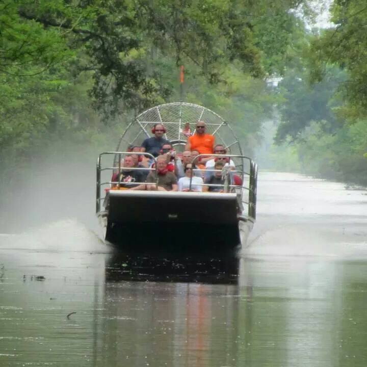 Guests riding an airboat through the misty Louisiana swamp