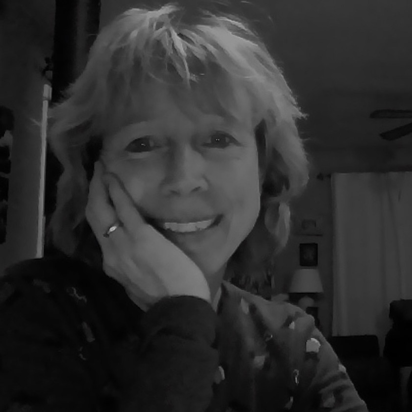 Leslie Ann Clark in her Whimsey Studio surrounded by original paintings and character sketches