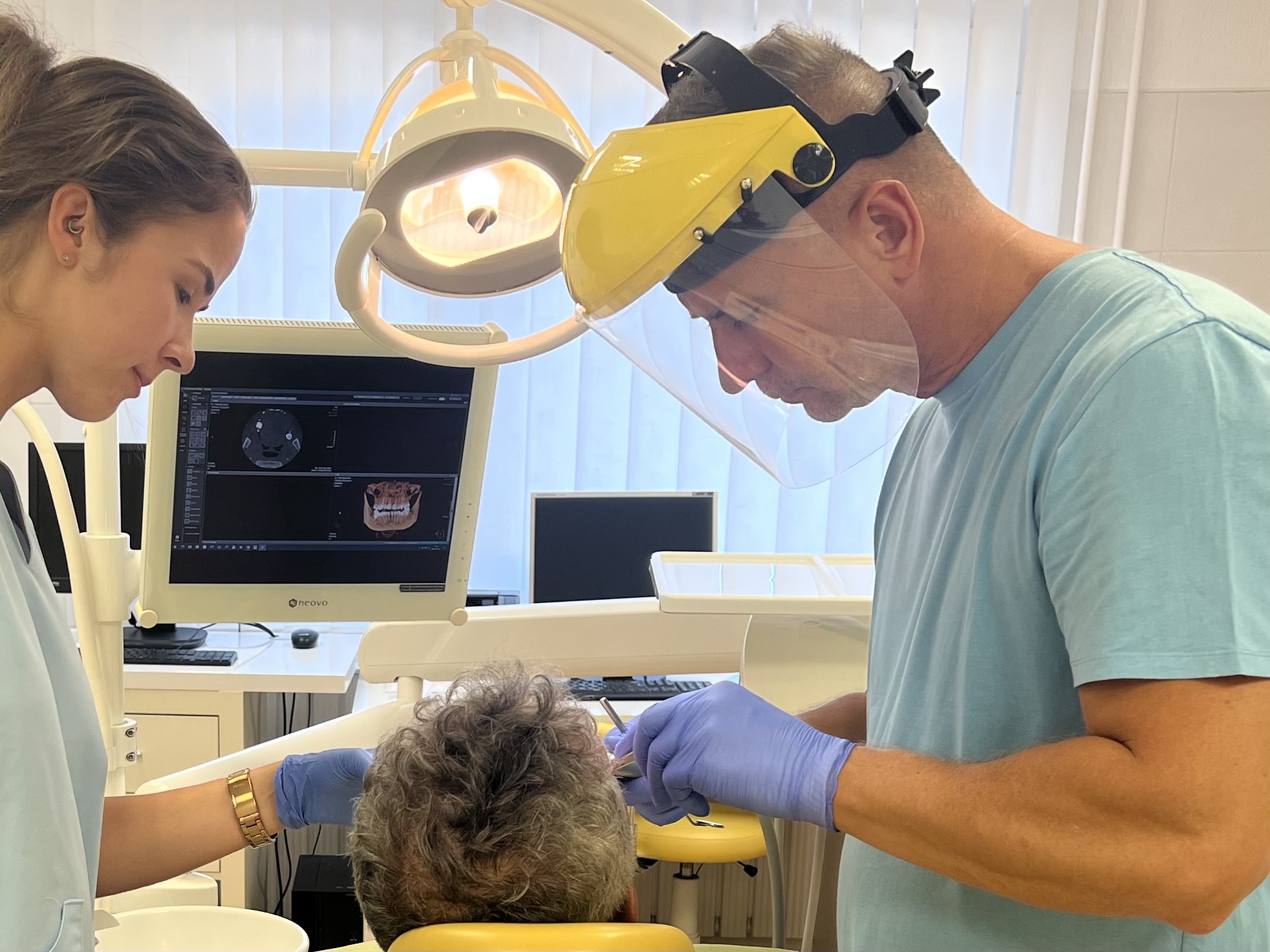 Dentist and assistant performing a dental treatment at DentalCom in Soltvadkert