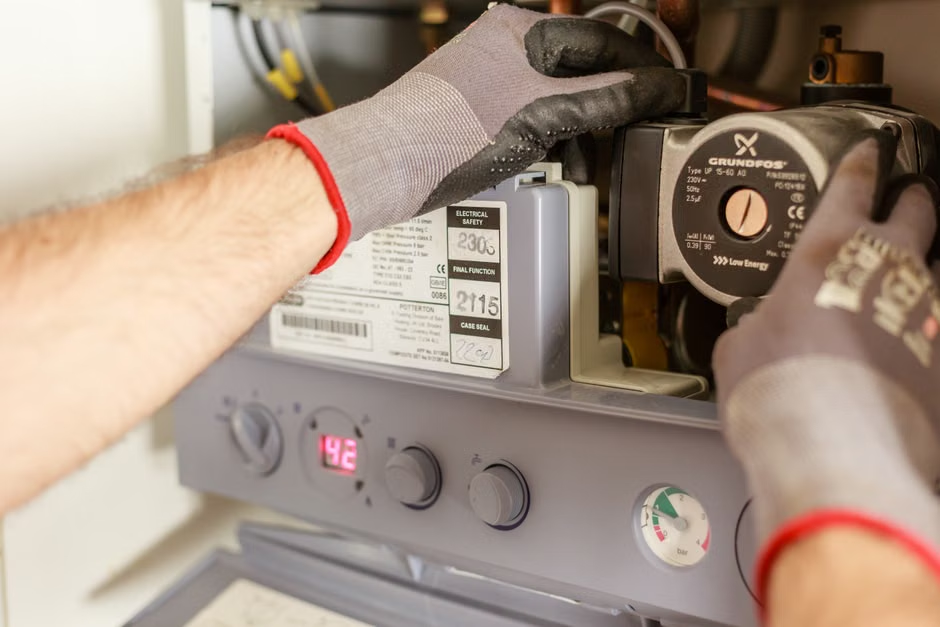 HVAC technician inspecting and tuning furnace internal components
