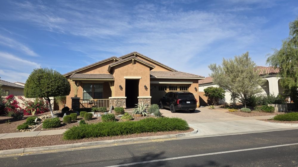 Completed front yard desert landscaping featuring mature trees and clean gravel