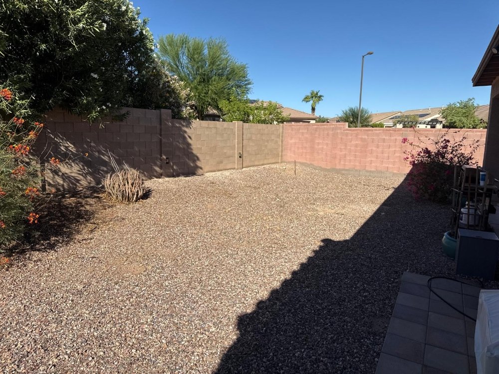 Before: Clean gravel backyard prepared for a new landscaping installation