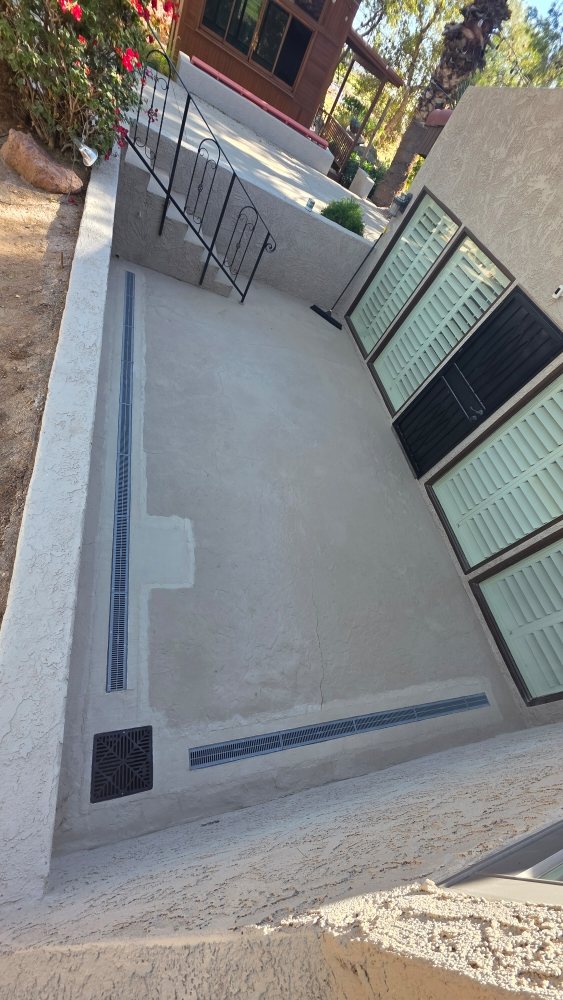 After: Custom concrete patio installation featuring linear drainage grates