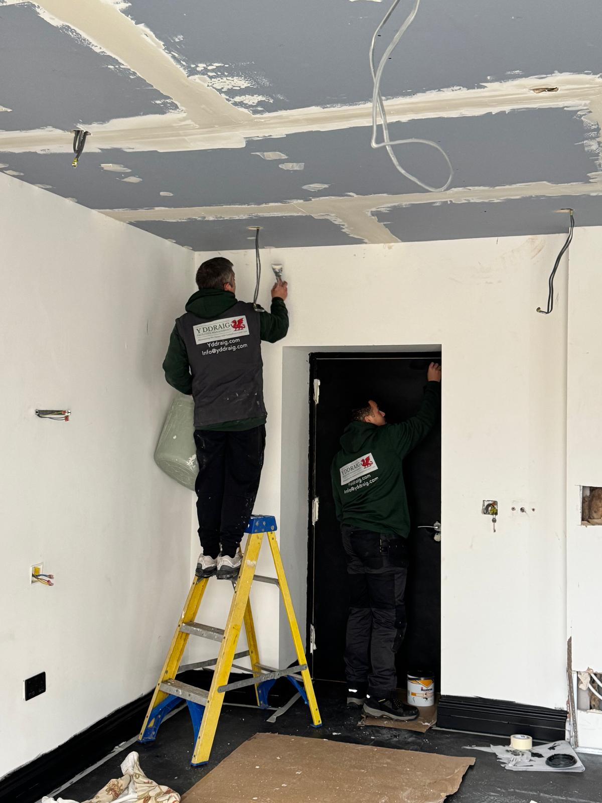 Y Ddraig Facilities Management technicians carrying out plastering and maintenance work at a property in Wales