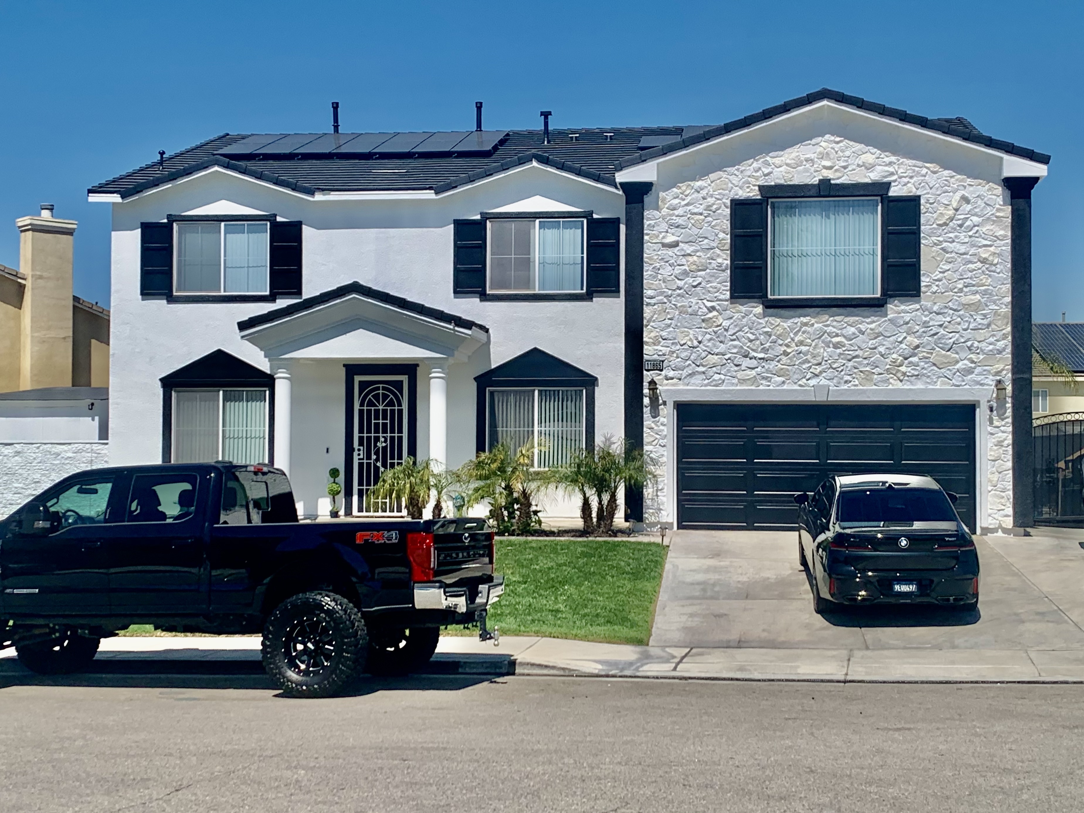 Two-Story Home with Stone Veneer & Black Shutters Accent