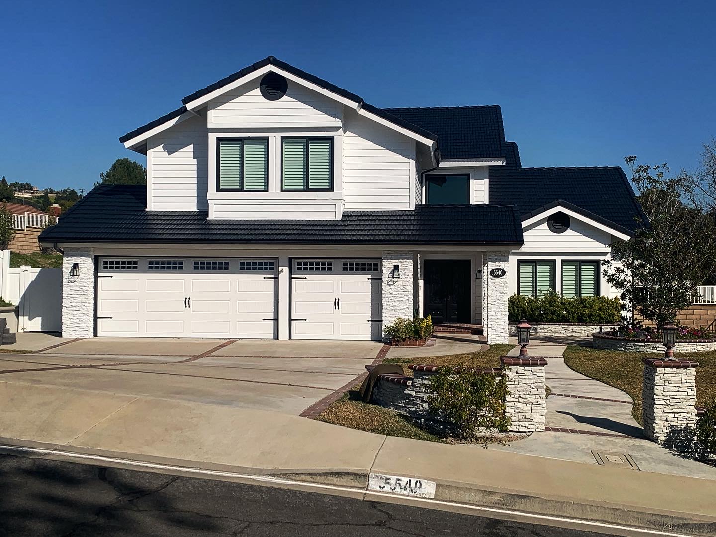 Beautifully painted white exterior home with dark tile roof by RPainter