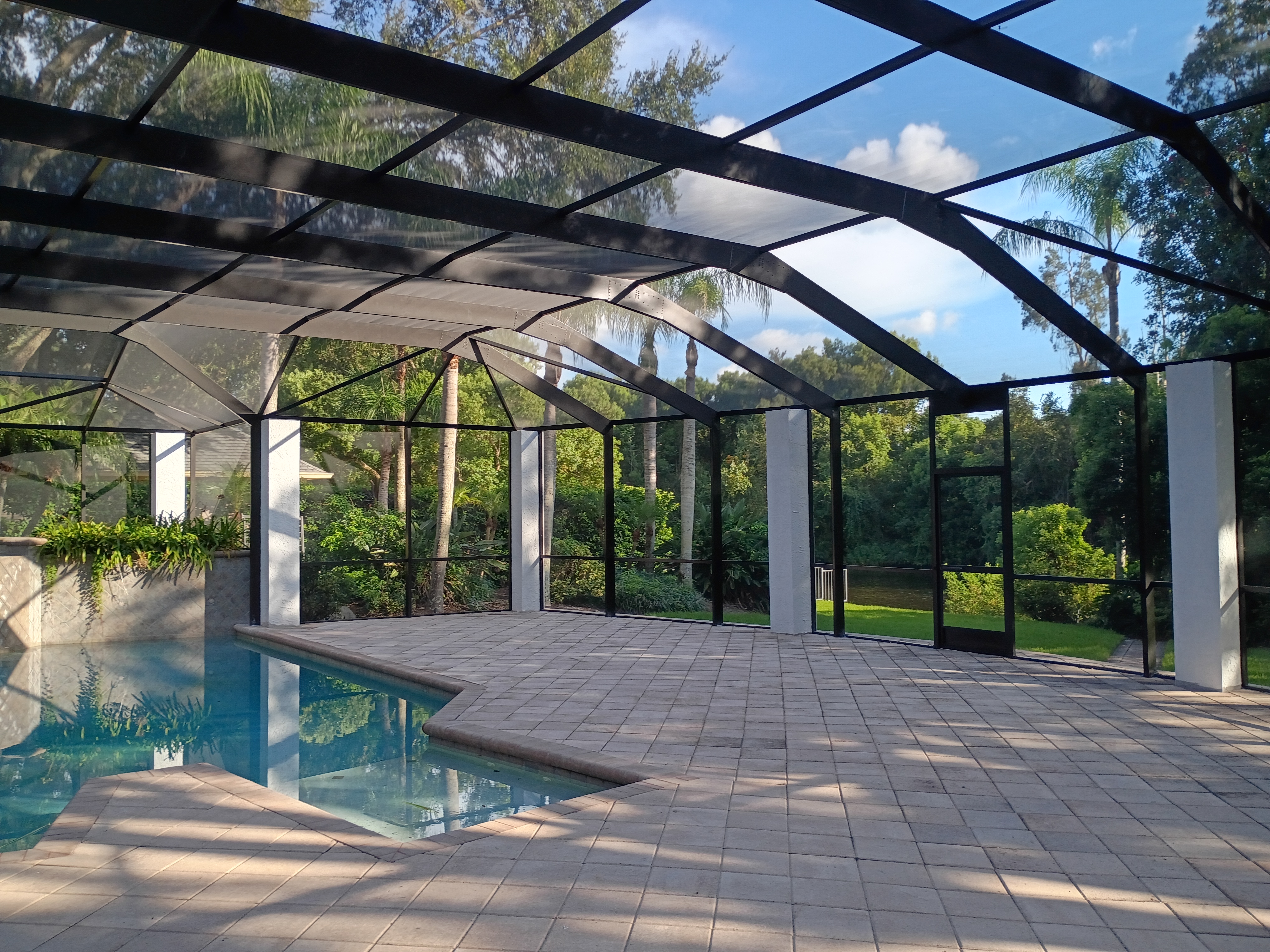 Interior view of custom Tampa pool enclosure with pavers and columns