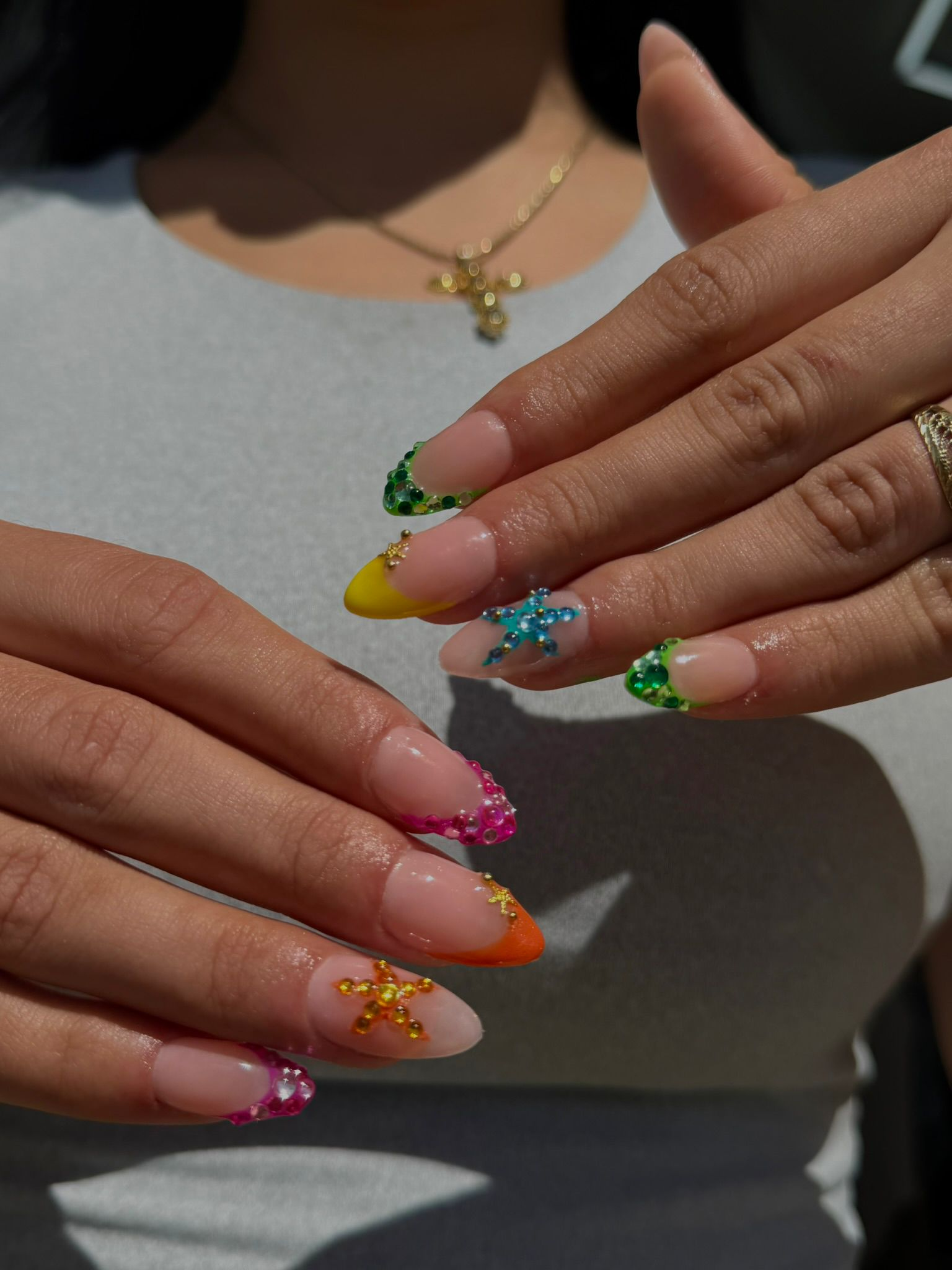 Manicura de estrellas y pedrería en tonos vibrantes
