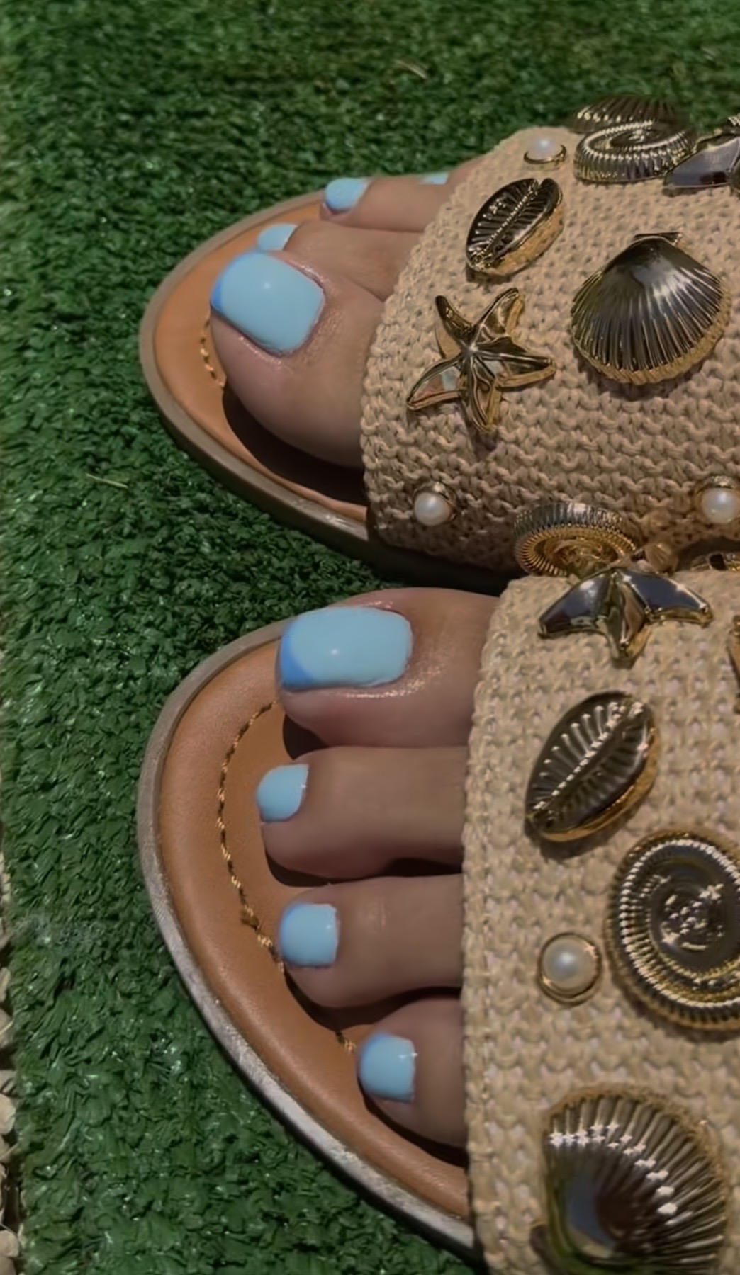 Pedicura con esmaltado azul pastel en sandalias decoradas con conchas