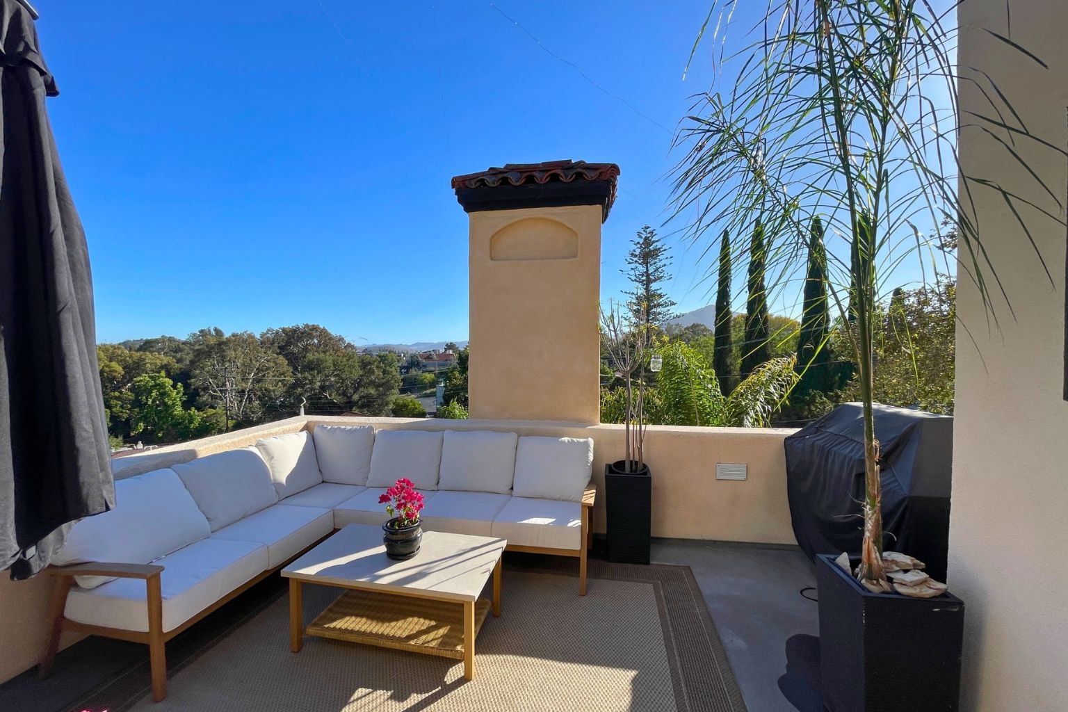Rooftop terrace with outdoor seating, a stucco chimney, and panoramic views of the surrounding hills and mountains