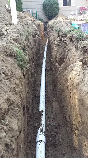 Newly installed white PVC sewer main line in deep excavated trench for residential property in Sandy Springs Atlanta GA Newly installed white PVC sewer main line in deep excavated trench for residential property in Sandy Springs Atlanta GA