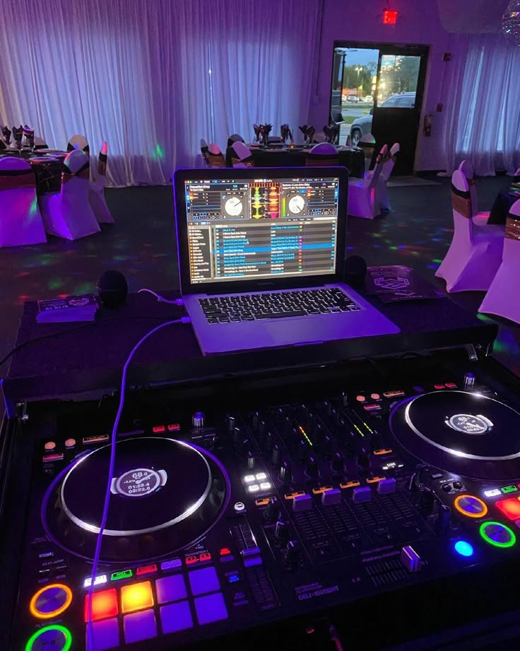 DJ Oscar console setup in ballroom with ambient event lighting