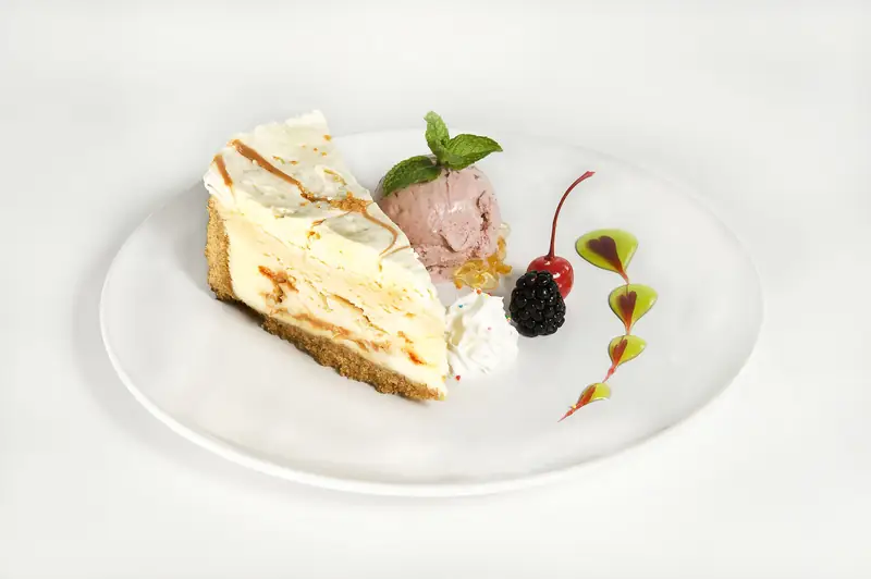 New York Style Caramel Cheesecake with artisan gelato and fruit garnish at Asian Bistro