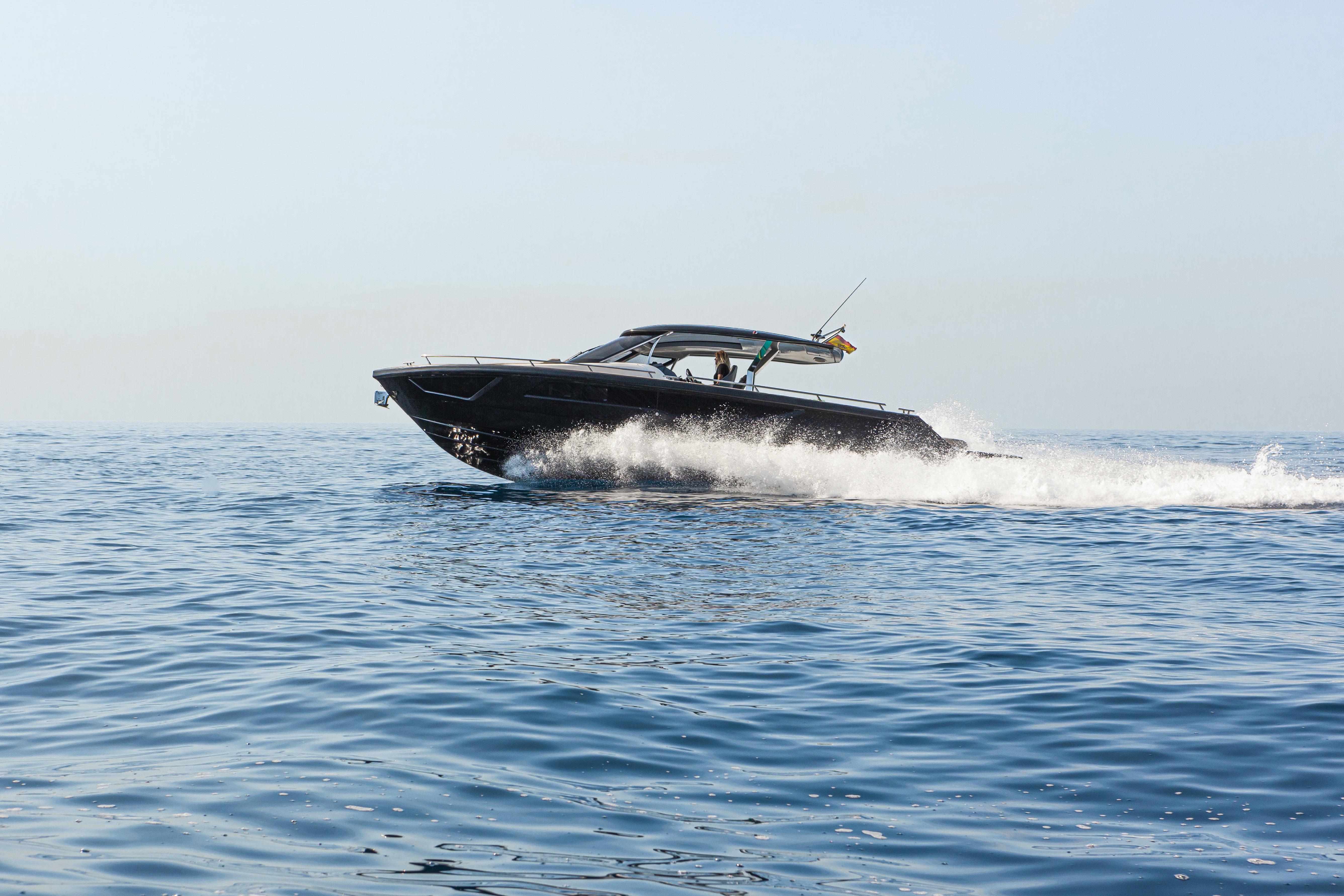 Private black yacht cruising off the Italian coast