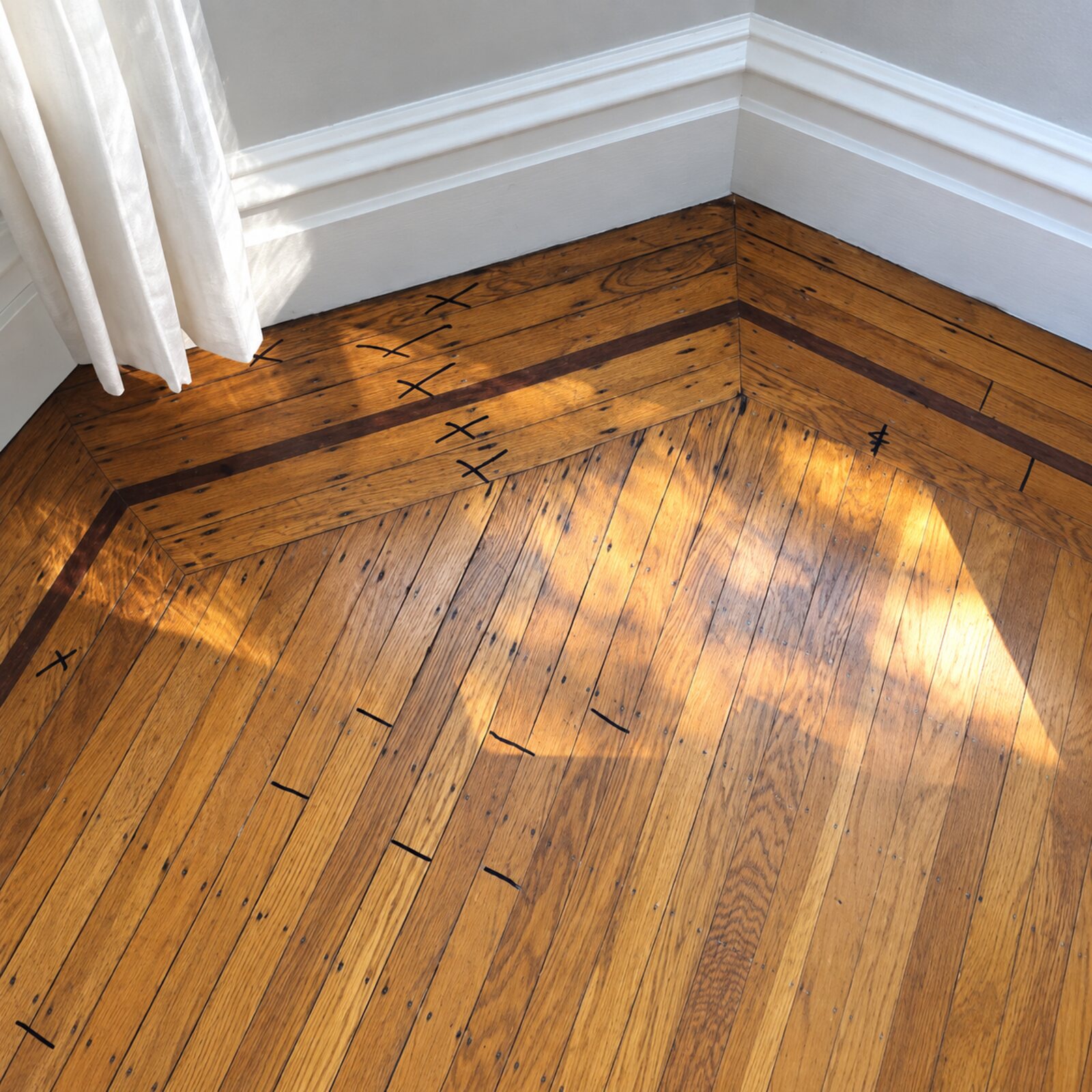 Close view of a herringbone hardwood floor in a warm amber finish