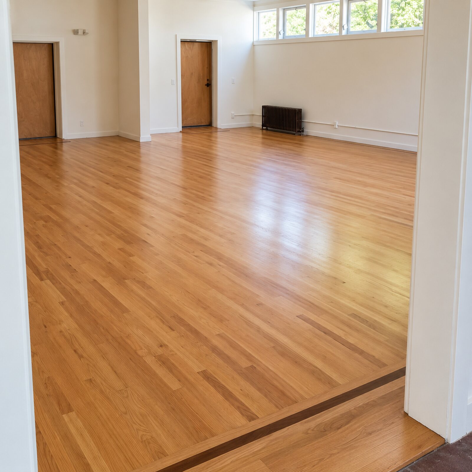 Restored hardwood floor with a dark inlaid border in an open room