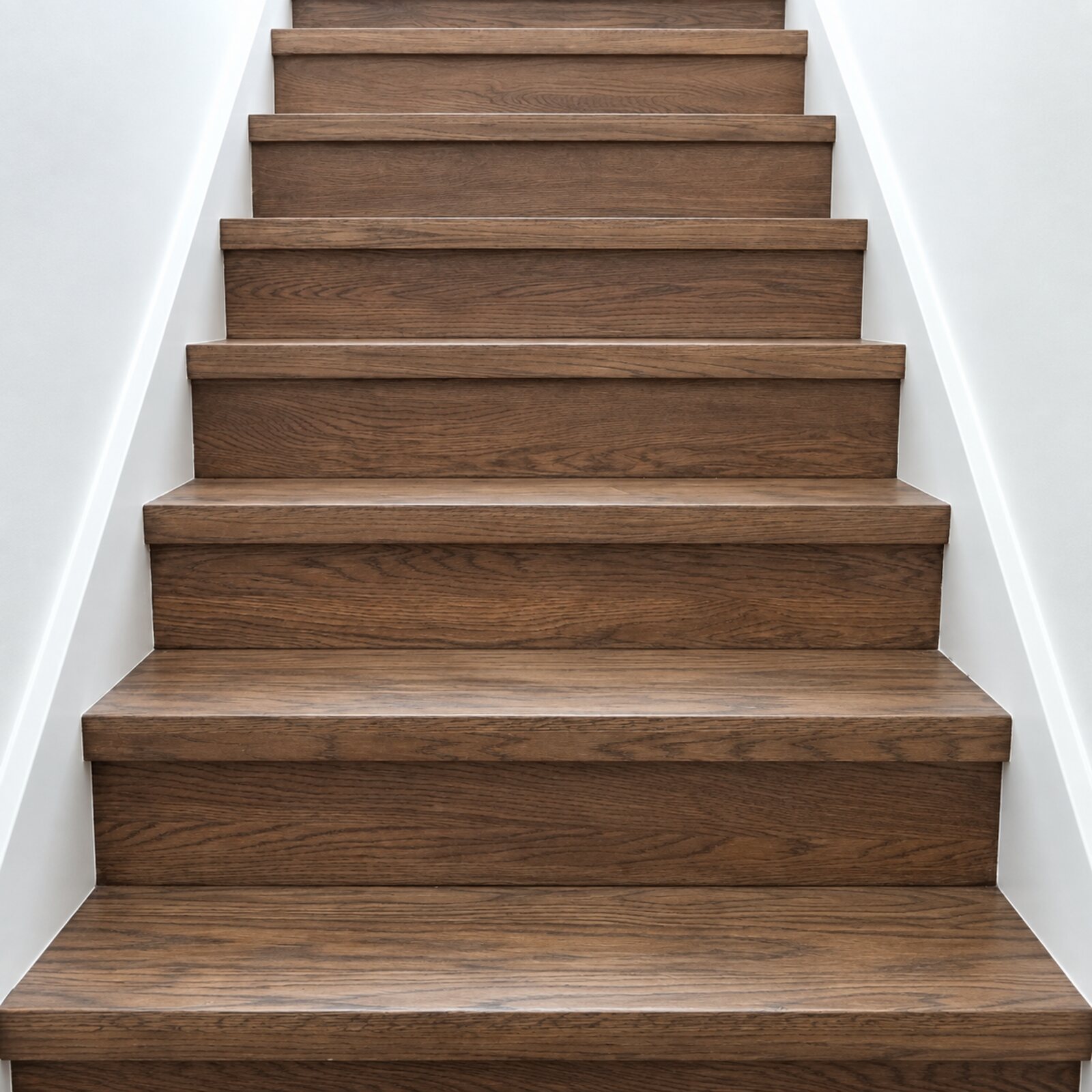 Dark-stained oak staircase rising to a landing