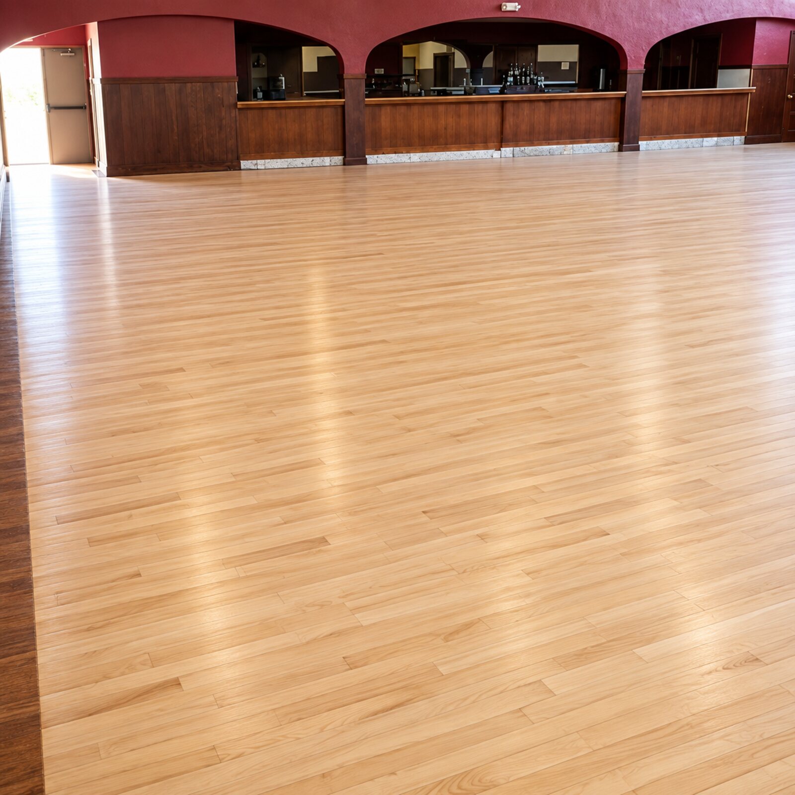 Refinished hardwood floor in a large commercial hall with a timber bar