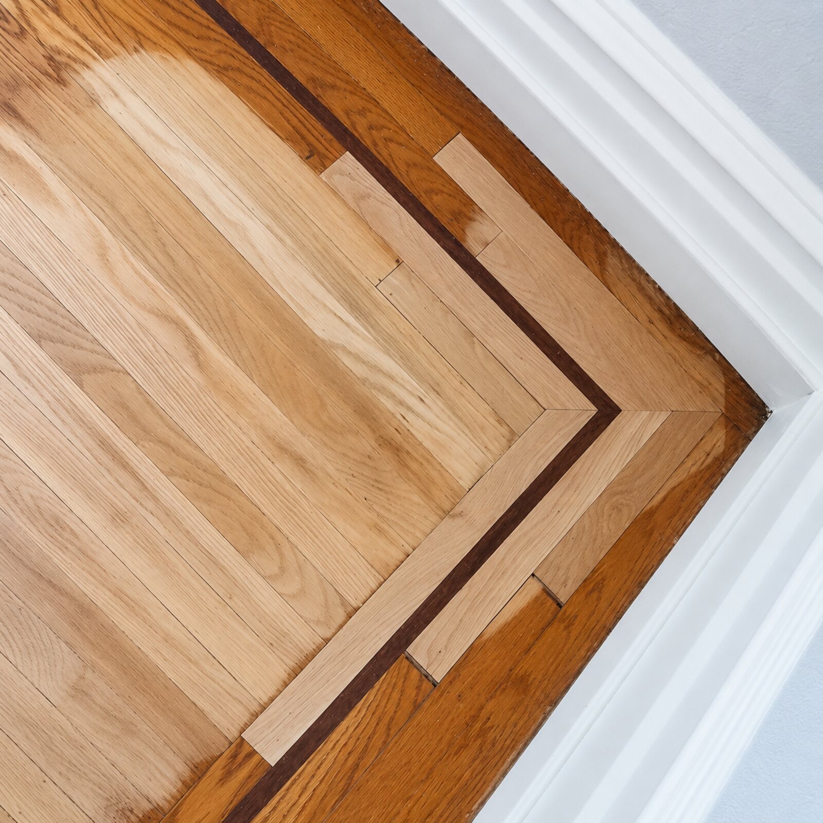 Close view of a mitred decorative floor border marked for repair