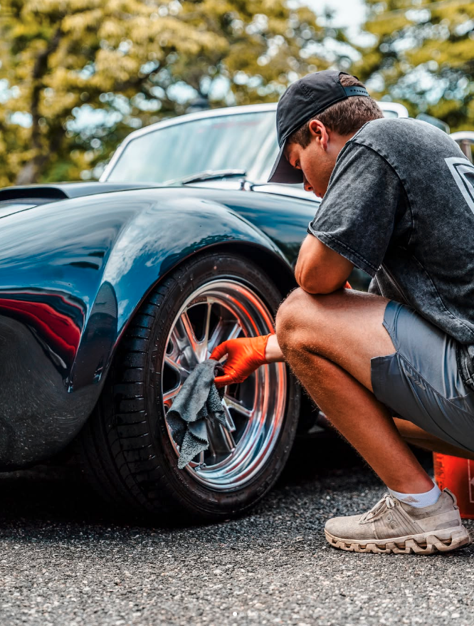Signature Mobile Car Detailing Savannah detailer meticulously wiping down a custom wheel rim by hand