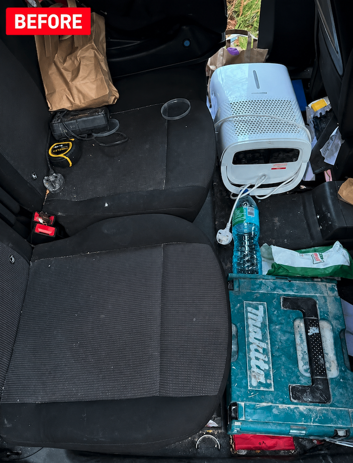 Cluttered rear seats with tools, equipment, and dirt before interior detailing